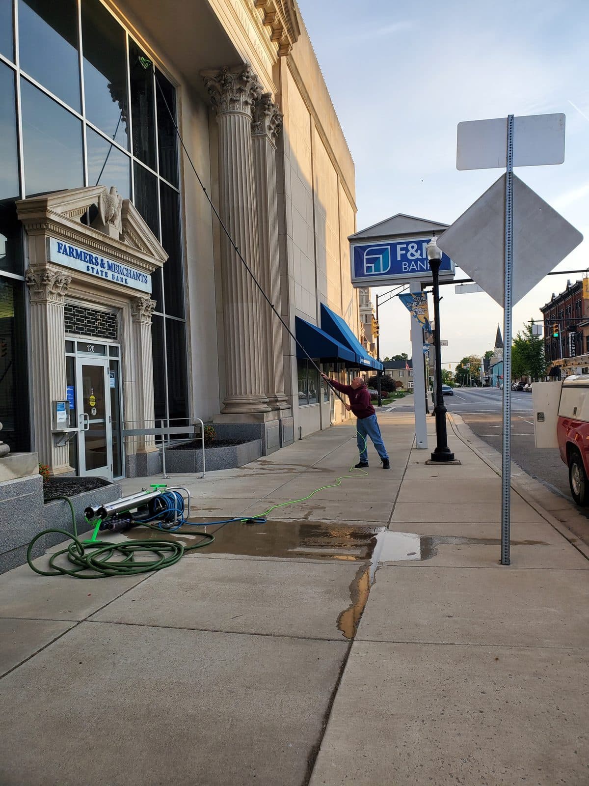 Aaron cleaning a historic storefront on the Urbana square